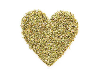 Green heart made from dried crushed marijuana weed isolated on white background. Legalize marijuana...