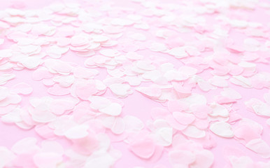 Festive romantic gentle abstract background for the design. Pink confetti in the shape of hearts on pastel background. Top view, flat lay composition. Copy space for text.