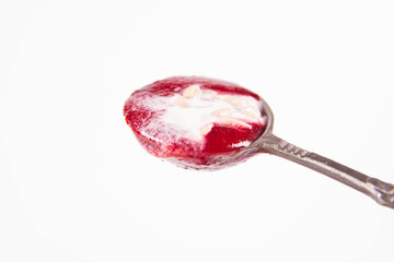 Beetroot cream soup, with yoghurt and sunflower seeds mixed in, on a vintage spoon