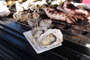 Two grilled oysters with toothpick