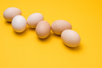 natural ecological eggs on yellow background in a row with copyspace
