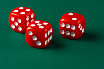 Red dice on green background close up