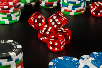 Dice and chips on black table close up