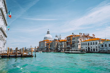 Venice, Italy. Beautiful view of turquoise-green colored Grand Canal and Basilica Santa Maria della Salute against blue sky