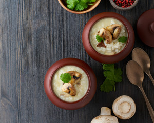Unconventional unusual serving of risotto with mushrooms in pot. Rice porridge with mushrooms.