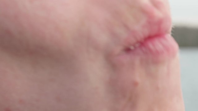 Woman's face eating chocolate. She smiles, showing dirty teeth. Close up view.