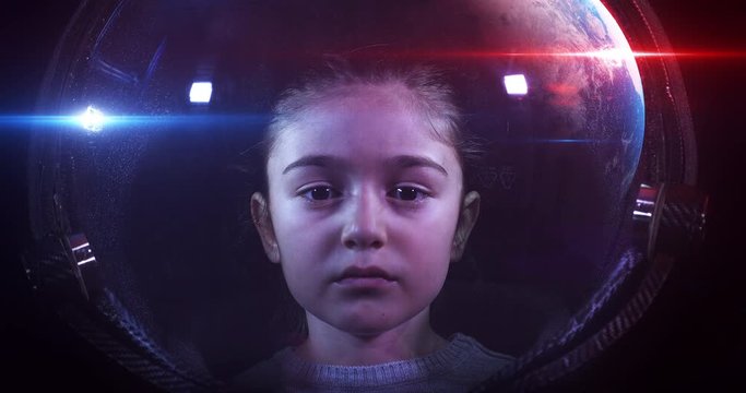 Beautiful Little Girl Astronaut In Space Helmet Looking At Camera. She Is Exploring Outer Space In A Space Suit. Science And Technology Related 4K Concept Footage.