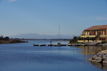 Fototapeta na wymiar Marina construction de bord de mer littoral avec maison et bateau et montagne