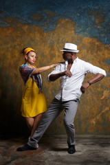 Elegant black man and beautiful white woman are dancing salsa.