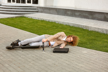 Young man fallen off his kick scooter outdoors