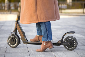 Young woman riding a kick scooter outdoors