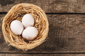 eggs in the hay nest on wooden table
