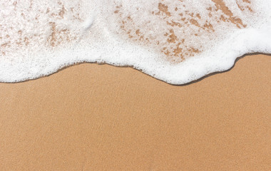 Soft wave and white bubble on brown sand on the beach