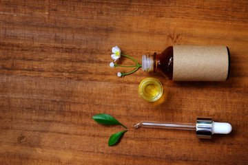 bottles of essential oil aroma with flower on wood background. for aroma spa alternative therapy medicine and meditation spa concept.