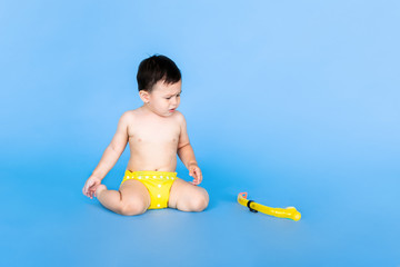 Holiday topic: child boy with snorkeling or diving equipment on a blue background. Adventure and rest concept