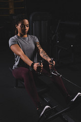 Fototapeta na wymiar athletic african american sportswoman with tattoo exercising in gym