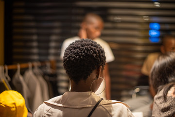 Woman with short hair and hoop earrings shot from behind