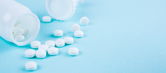 White tablets on a blue-green background. Copy space for text or disign - obrazy, fototapety, plakaty