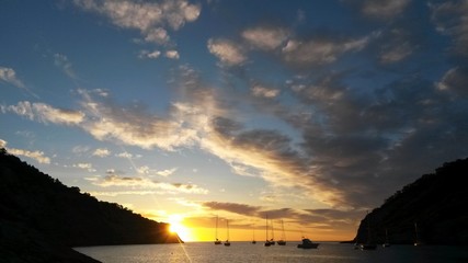 Yellow sunset with Beautiful sky, Silhouette of hills and boats 