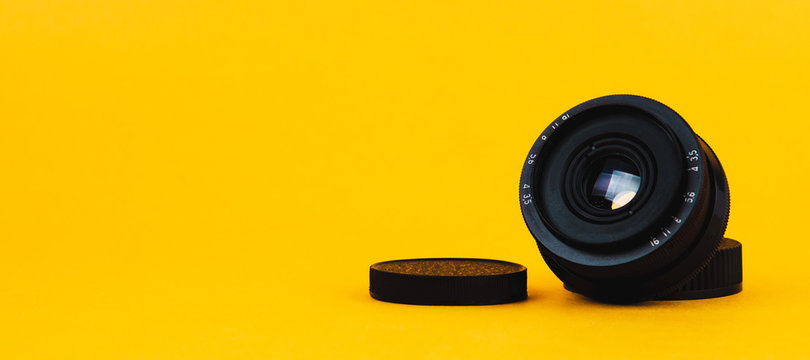 Photo lens on yellow background. Copy space for text or design