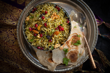 Vegan  Indian rice pilaf made with aromatic spices, curry leaves, nuts, seeds, raisins and pomegranate seeds