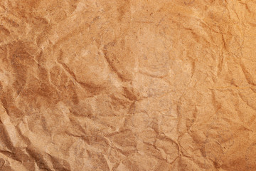 Old crumpled parchment paper texture background. Brown surface structure. A sheet of yellowed wrapping paper.