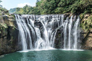 Fototapeta premium Wodospad Shihfen, wysoki na 15 metrów i szeroki na 30 metrów, jest największym wodospadem typu kurtynowego na Tajwanie