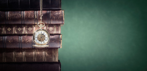 Pocket watch and books background in library or study