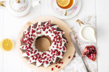 chocolate cake with pomegranate on a white table, a cozy breakfast, English tea party, chocolate dessert, a delicious cake with pomegranate, a photo of sweet food with free space for text