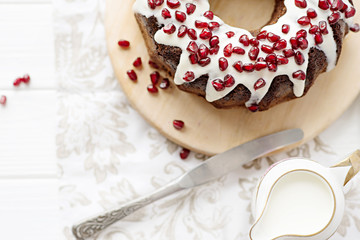 chocolate cake with pomegranate on a white table, a cozy breakfast, English tea party, chocolate dessert, a delicious cake with pomegranate, a photo of sweet food with free space for text