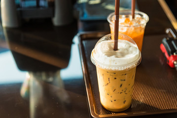 Iced coffee on wood table in coffee shop.