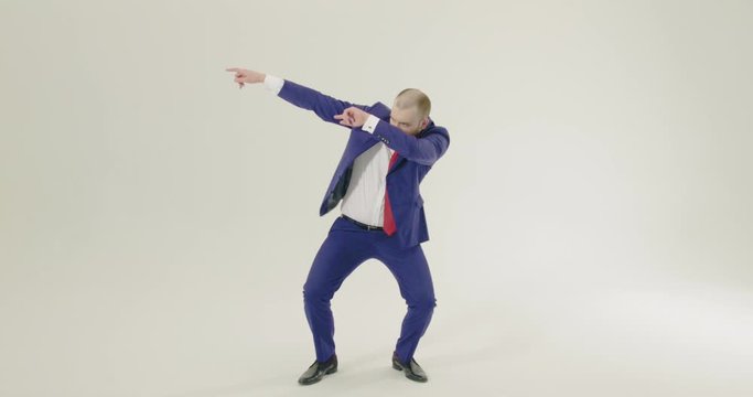 Smartly dressed businessman dabbing on a white background - Wide Shot