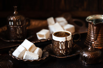 Traditional turkish coffee and turkish delight in traditional oriental copper serving set. Dark vintage background