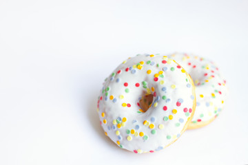 two glazed donut with colored sprinkles on white background