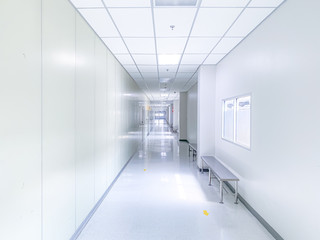 Illuminated long white corridor in modern office building