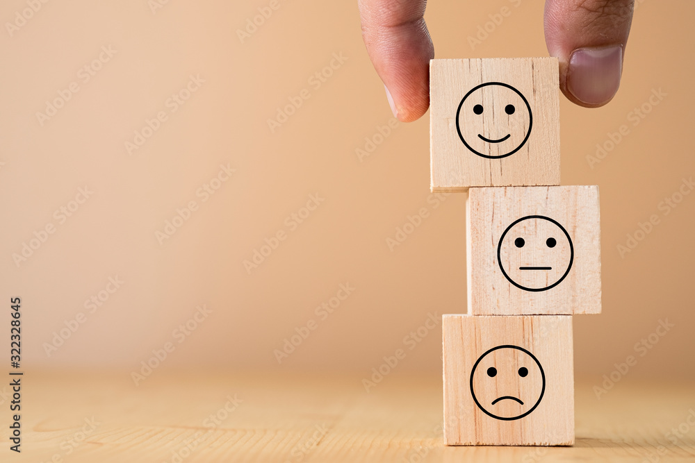 Poster Hand select and putting smile cube emotion for stacking to normal and sad emotion wooden cubes.Excellent manage mindset and mood.