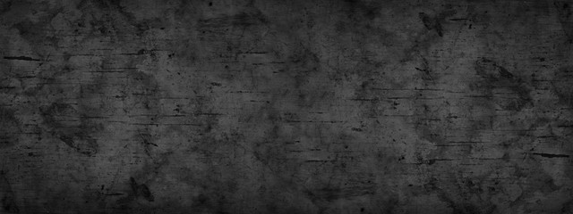 Black grunge background. Dark gray rough dirty surface texture. Close-up. Distressed backdrop. Black abstract wide grunge banner with copy space for your design.