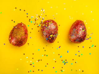 Premium gold Set of 3 golden red easter eggs painted with innovative acrylic on yellow background...