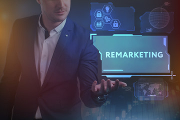 Business, Technology, Internet and network concept. Young businessman working on a virtual screen of the future and sees the inscription: Remarketing