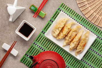 Fried Gyoza, Dim Sum or dumplings snack is Japanese food and Chinese food, with  white plate ceramic and sauce and  tea pot. Top view