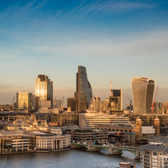 City of London at dusk. Landmark skyscrapers in the financial district of the UK capital with the River Thames in the foreground.