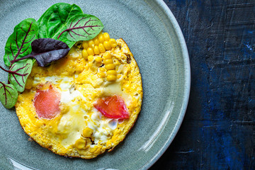omelette scrambled vegetables and salad, healthy snack (corn, tomato, onion and other ingredients) menu concept background. top view. copy space