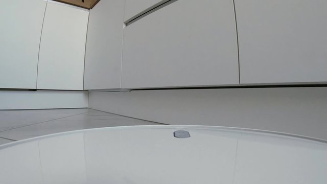 4k footage, robotic vacuum cleaner moves to charge station after hoovering tiled floor, view from robot