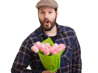 Bearded young handsome man holding a bouquet of pink tulips looking surprised, isolated on white background. Mothers day, Valentines day, Easter and surprise Concept.