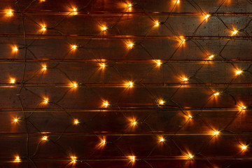 Leuchtendes Lichternetz vor einer Holzwand