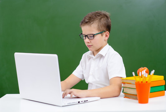 Small cute boy work on laptop device
