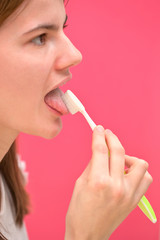 Woman Cleaning Tongue Using Toothbrush
