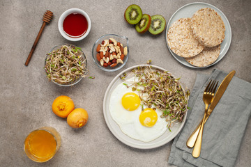 Fototapeta na wymiar Healthy breakfast with egg, bean sprouts, fruit, honey and juice. Top view. Flat lay