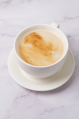 cappuccino in a white cup on a white background close-up
