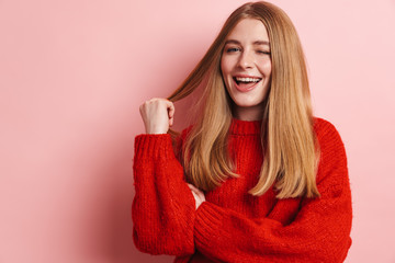 Photo of happy woman smiling and winking while posing